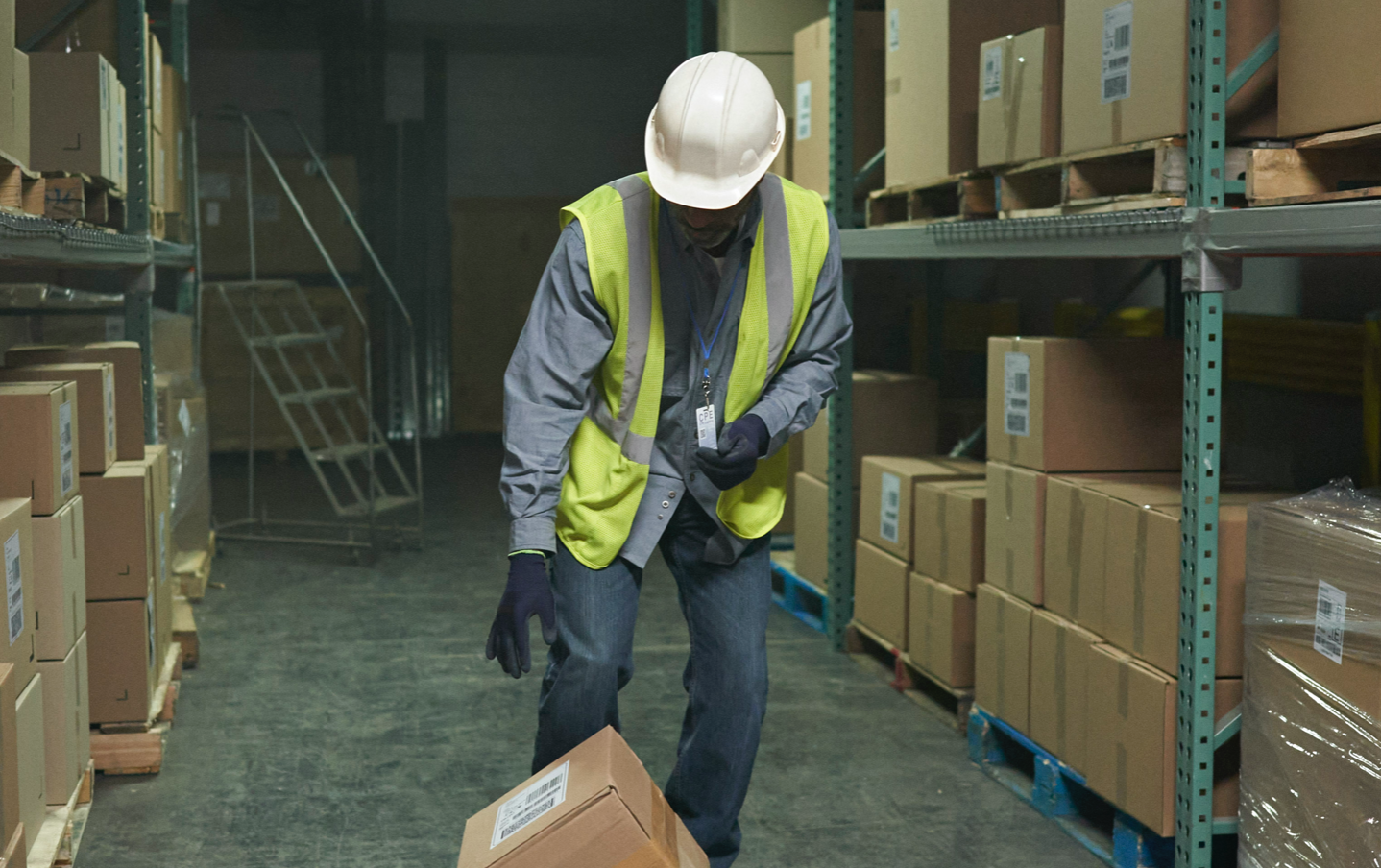A man carrying a box in a warehouse.