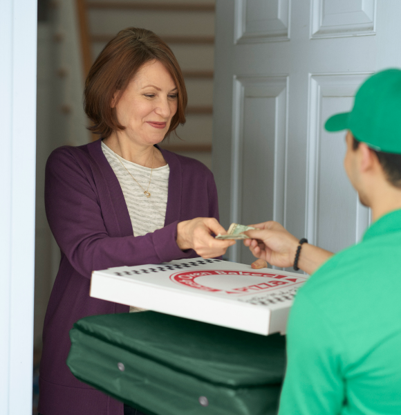 A woman receiving a delivery pizza.